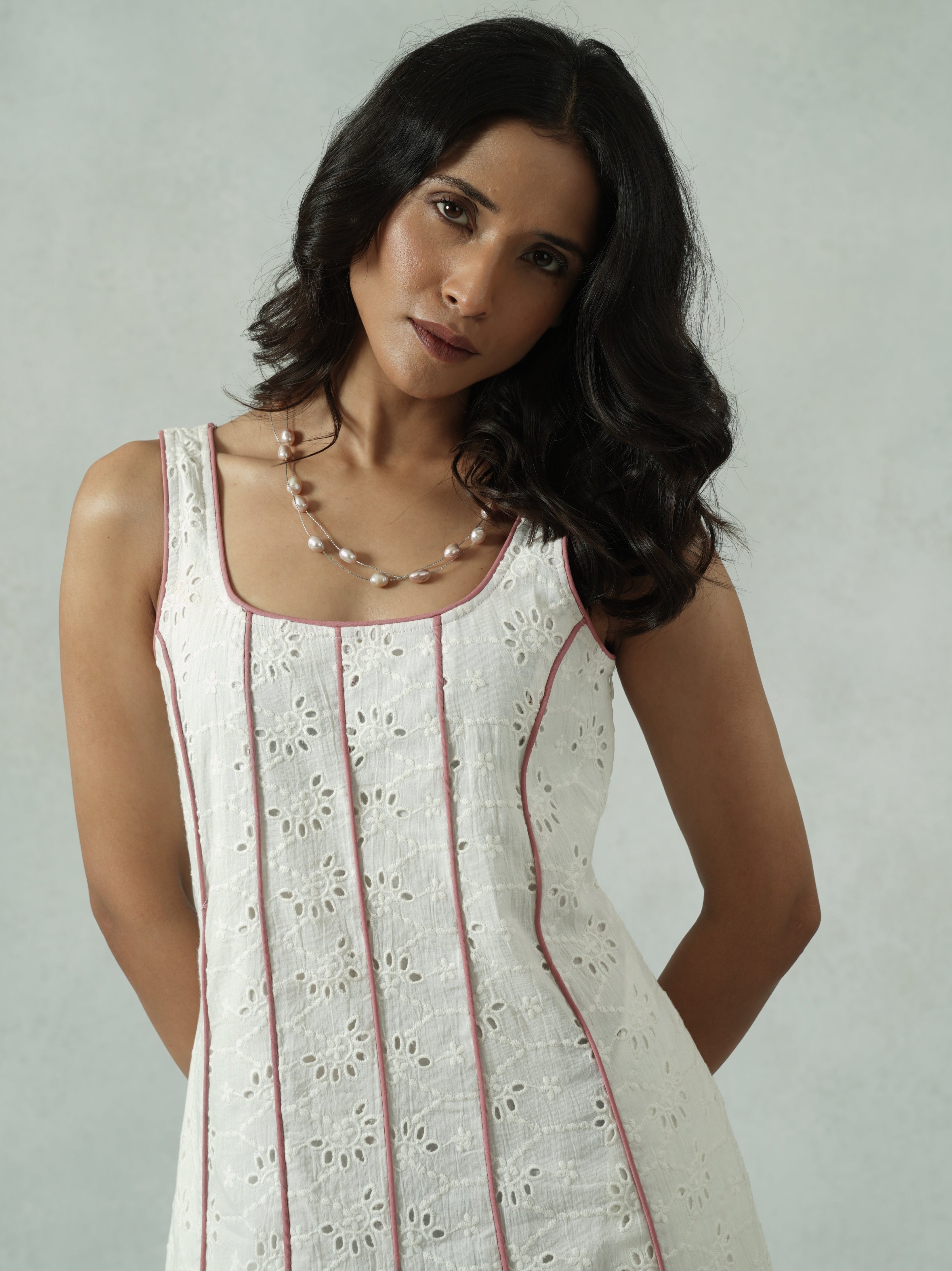 Woman in a white dress with red stripes against a light gray background