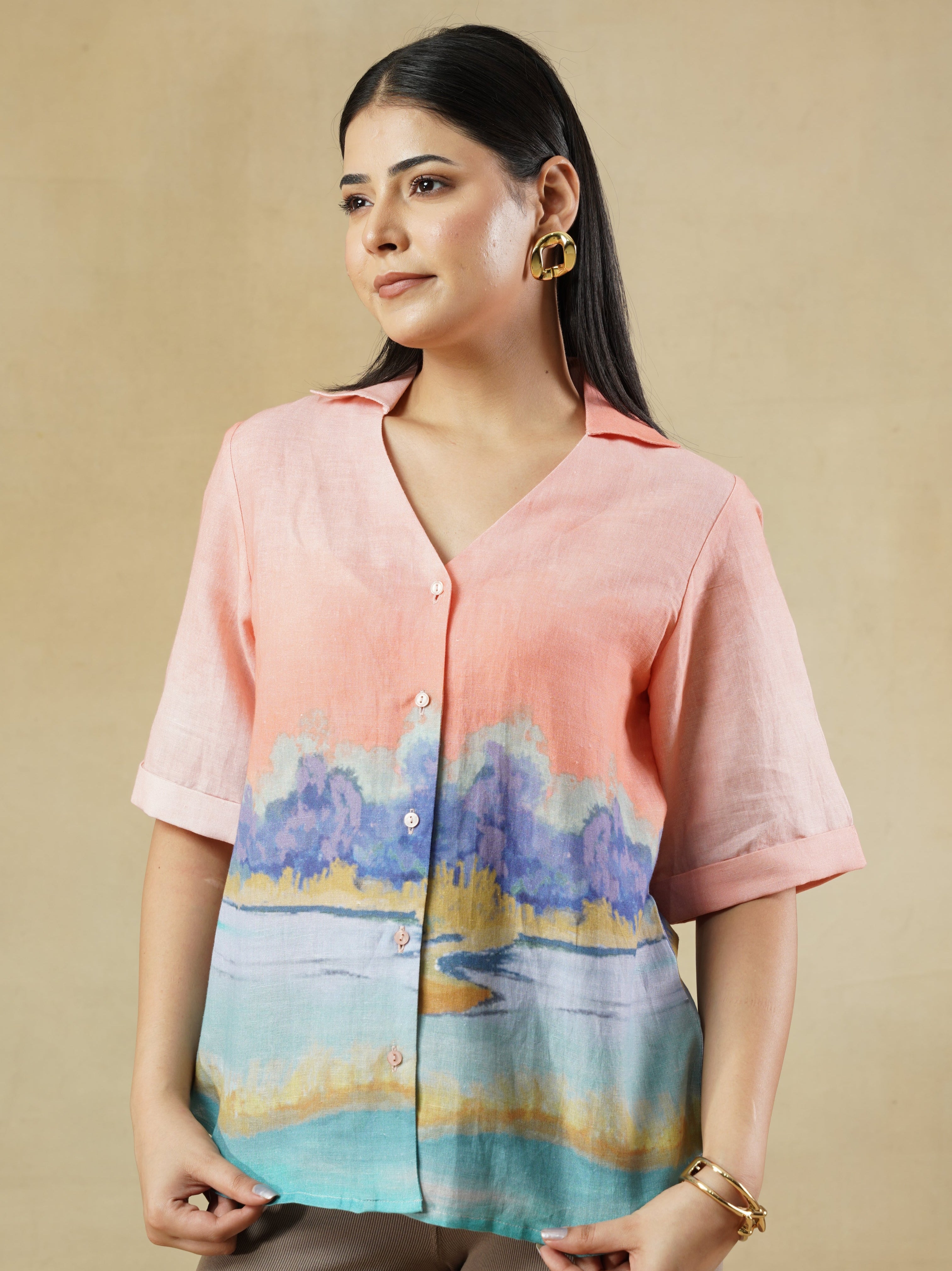 Woman wearing a colorful top and skirt against a beige background