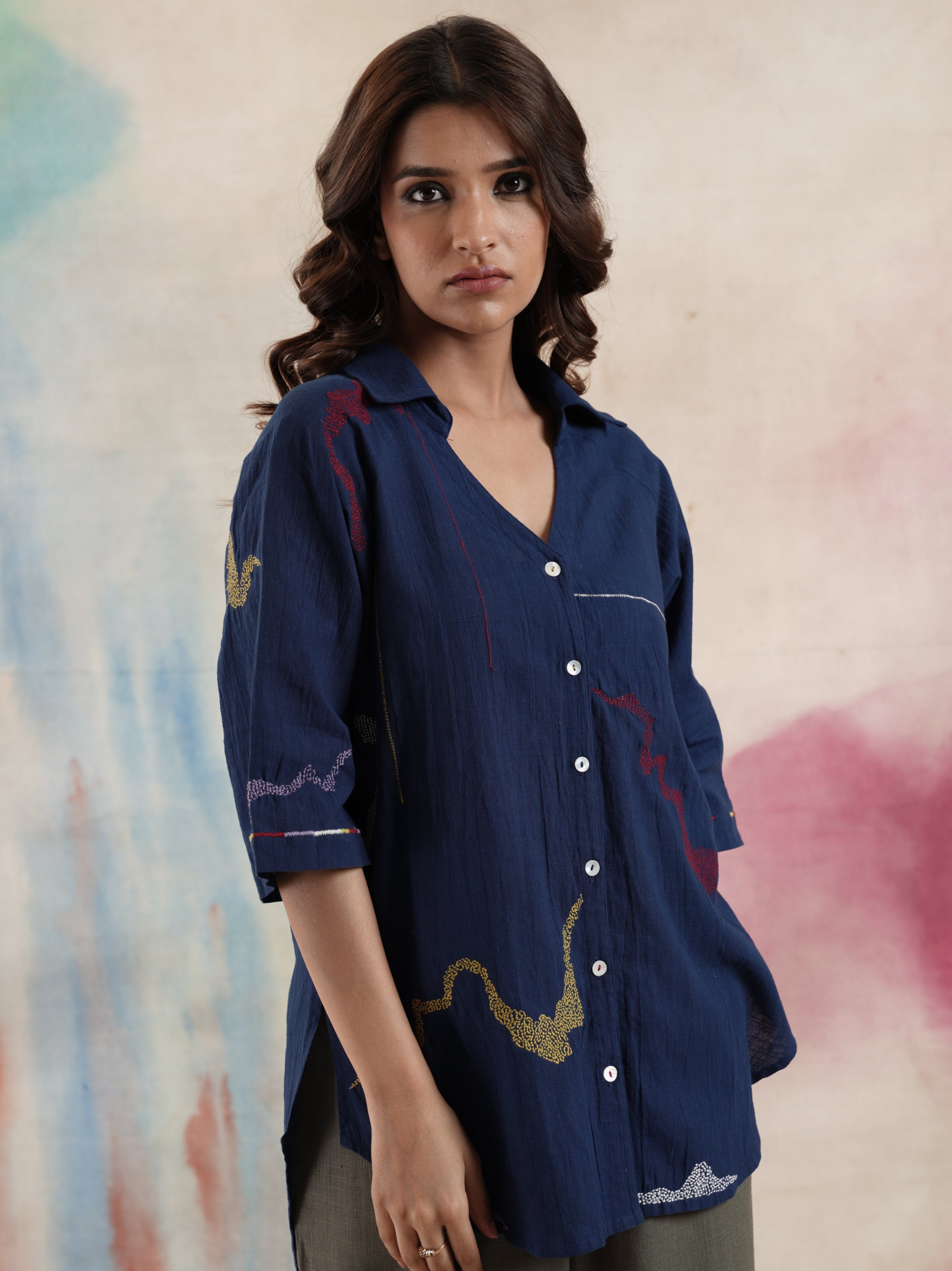 A woman modeling a navy blue cotton embroidered shirt with a collar, button-up front, and 3/4 sleeves.