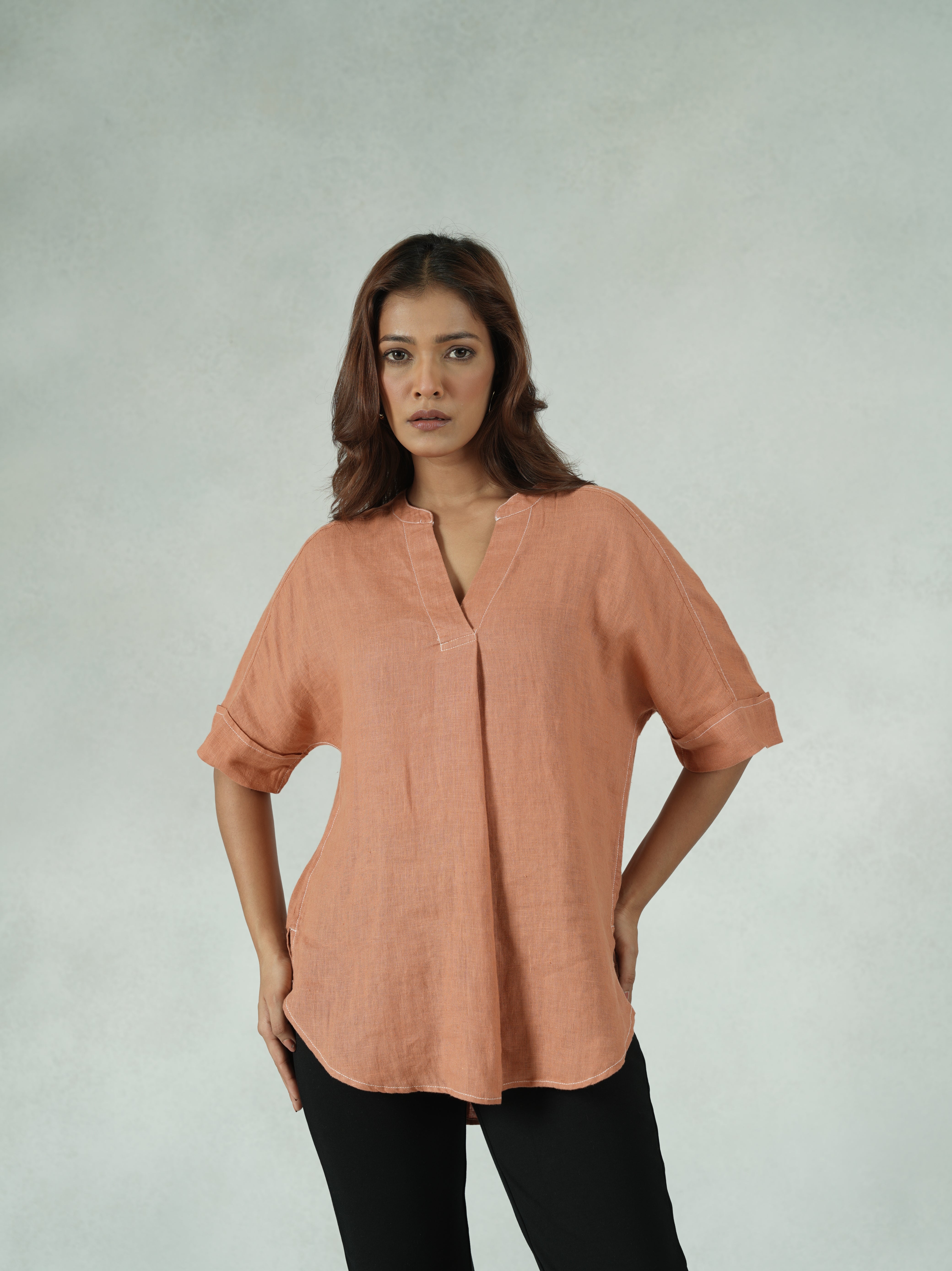 Woman wearing a peach-colored jacket on a plain background