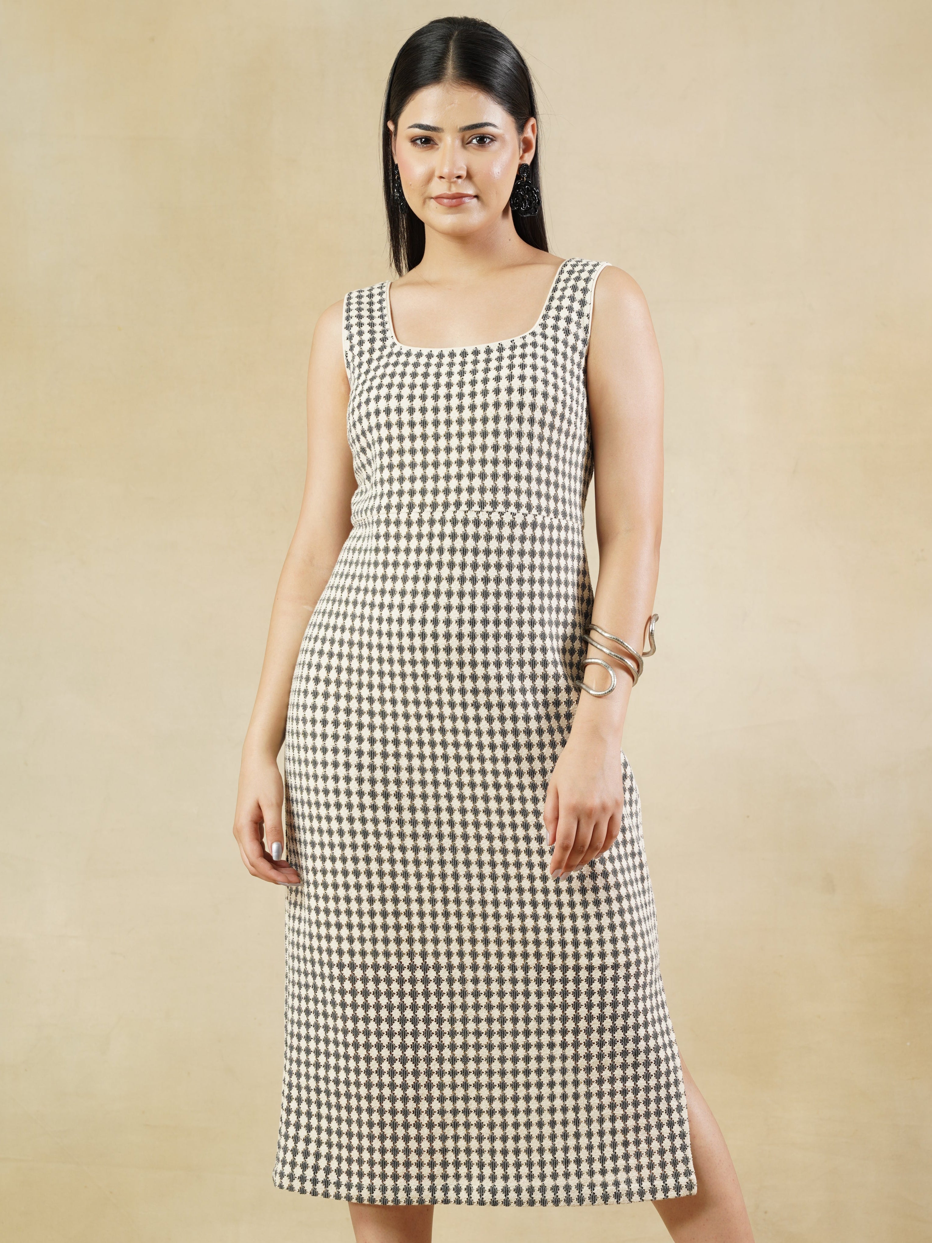 Woman wearing a black and white checkered dress on a beige background