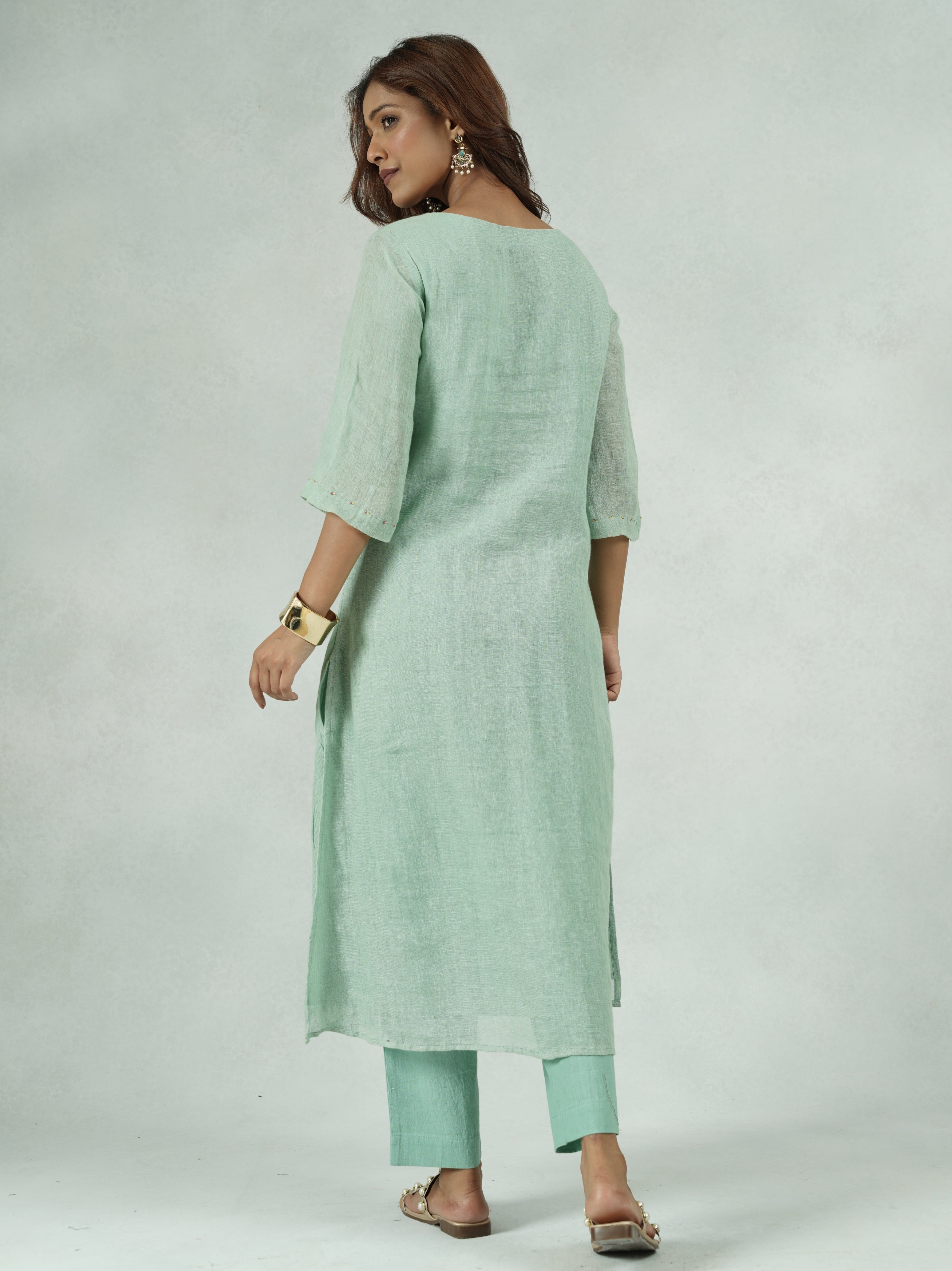 Woman wearing a light green dress on a white background