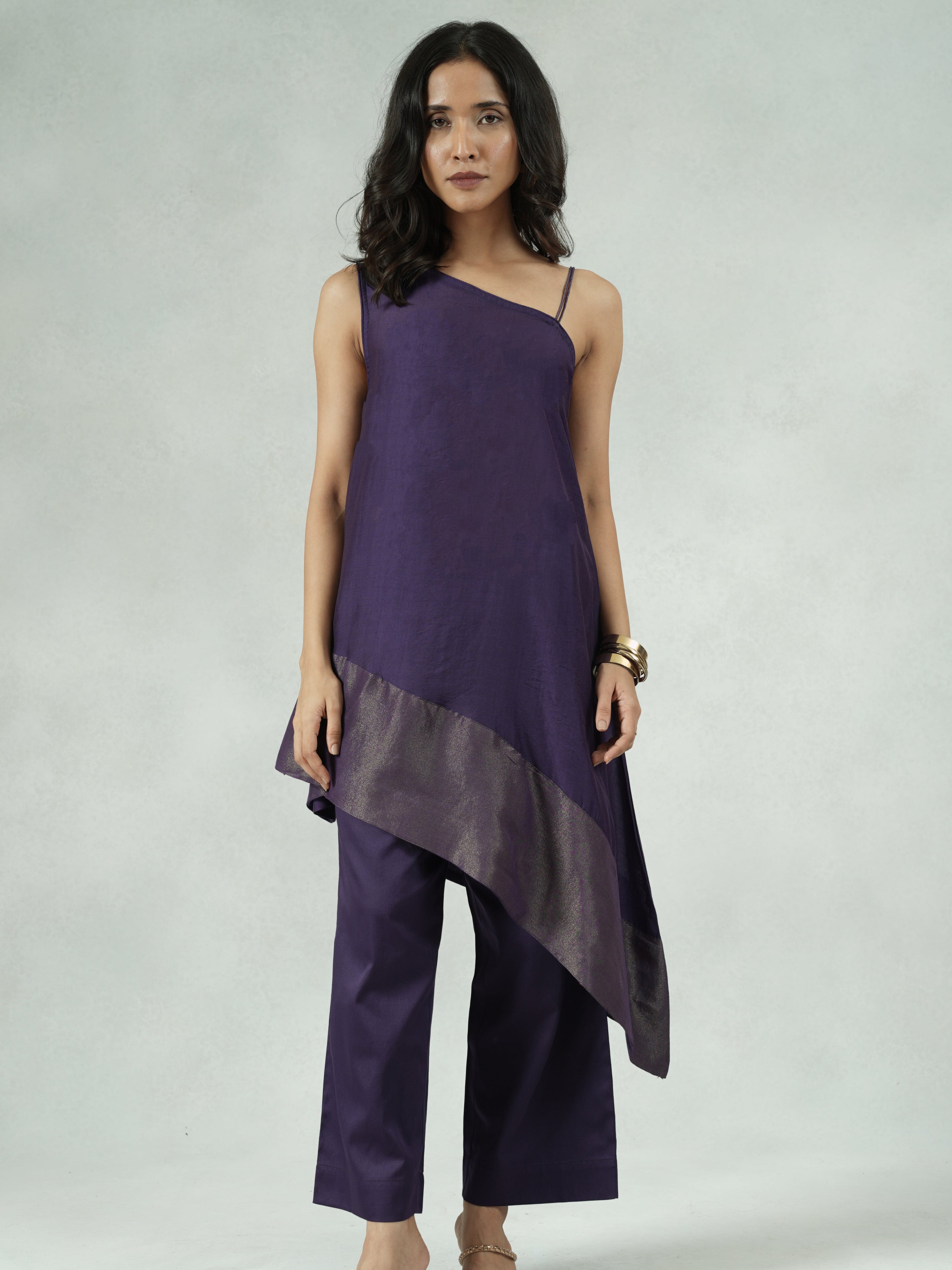 Woman wearing a purple dress with a gray bottom section on a white background